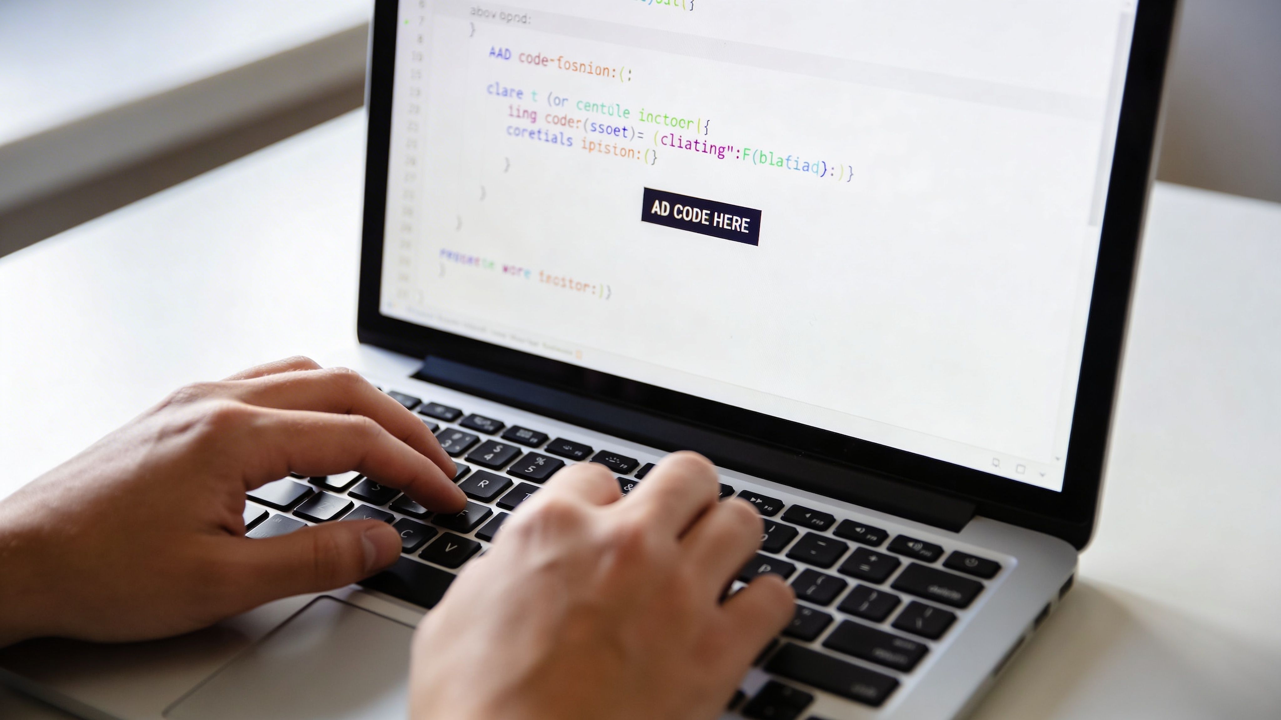 A developer typing on a laptop computer screen displaying code with a placeholder for advertisements.